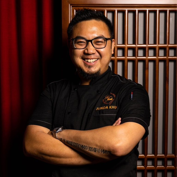 Junda Khoo standing arms crossed and smiling, wearing his chef uniform.