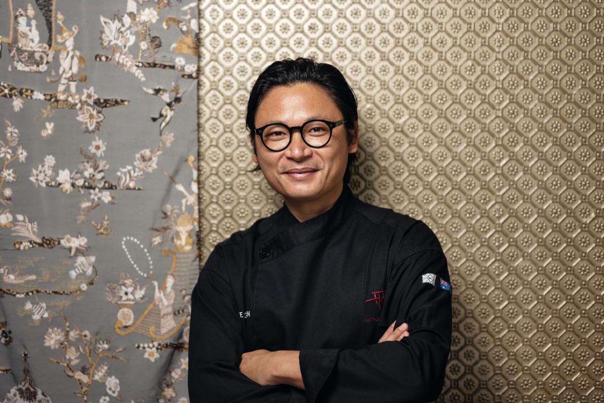 Luke Nguyen standing arms crossed, smiling, wearing his chef uniform.
