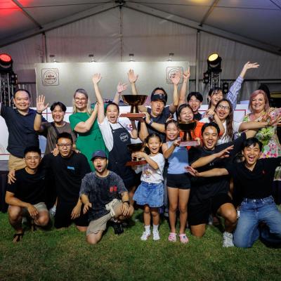 The Kopi Stop team members celebrating their awards by throwing their hands in the air, in front of the Kitchen stage