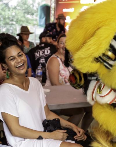 Man and woman laughing while Chinese dragon approaches