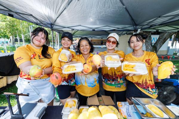 The Hugs Panim team members posing with mangoes and containers of rice. 